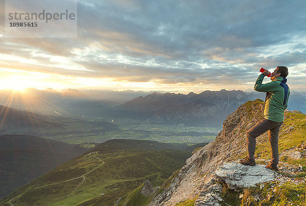 Österreich  Tirol  Wanderer trinken  Sonnenuntergang