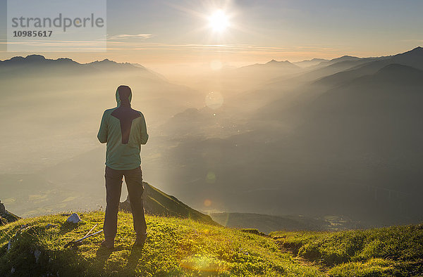 Österreich  Tirol  Wanderer bei Sonnenaufgang in der Ferne
