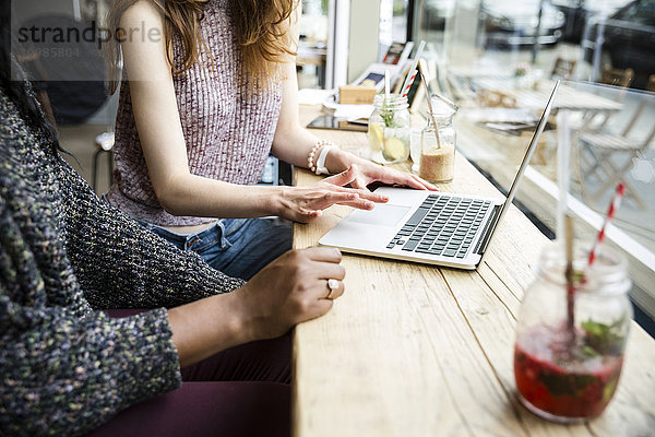 Zwei Freunde  die ein Meeting-Café haben  mit Laptop