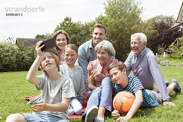 Junge nimmt Selfie der glücklichen Großfamilie in den Garten