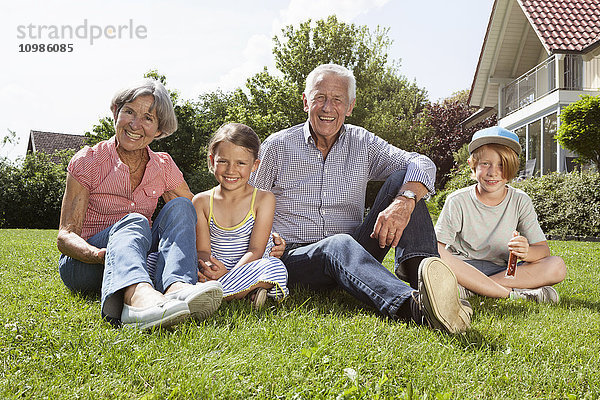 Porträt glücklicher Großeltern mit Enkelkindern im Garten