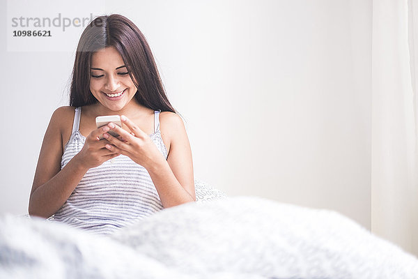 Teenager-Mädchen wacht auf  liest Nachricht auf dem Smartphone