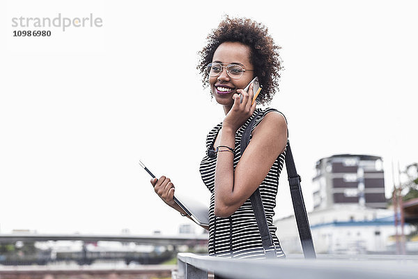 Lächelnde Geschäftsfrau beim Telefonieren mit dem Handy