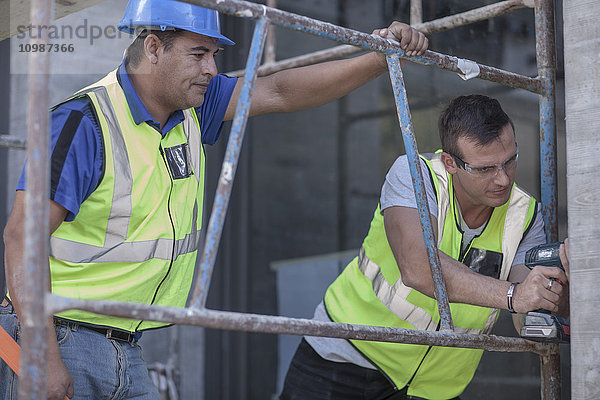 Zwei Bauarbeiter auf dem Gerüst auf der Baustelle