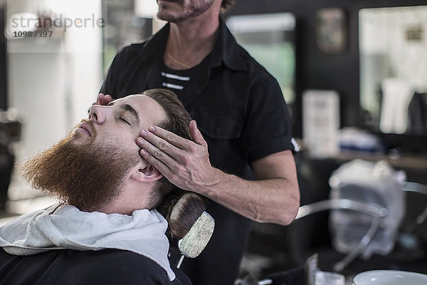 Friseurmaßnahmen am Kopf des Kunden vor dem Haarschnitt im Friseursalon
