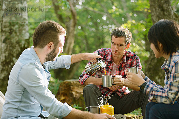 Multiethnische Gruppe von Freunden beim Kaffee auf einem Campingplatz