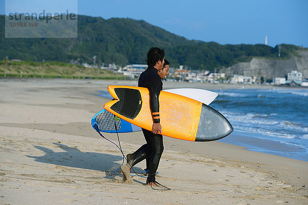 Japanische Surfer am Strand
