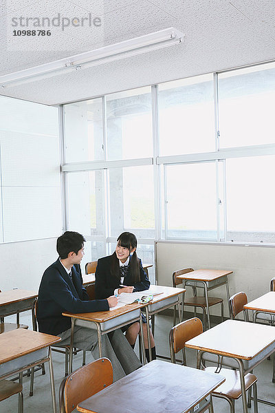 Japanische Gymnasiasten in einem leeren Klassenzimmer