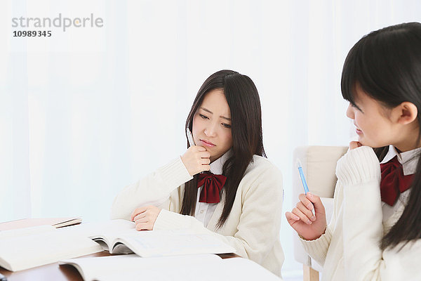 Japanische Gymnasiasten in Uniform beim gemeinsamen Lernen