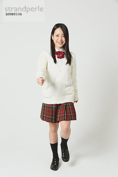 Japanischer Gymnasiast in Uniform vor weißem Hintergrund