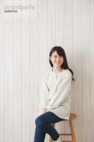 Junge japanische Frau vor Holzwand