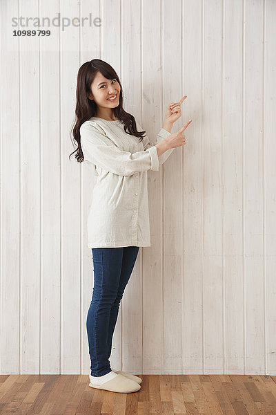 Junge japanische Frau vor Holzwand
