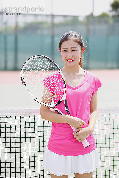 Junge japanische Tennisspielerin auf dem Platz