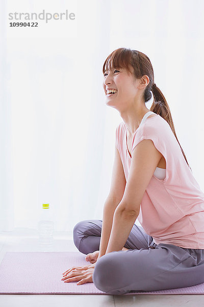 Junge Japanerin entspannt sich nach einer Yoga-Praxis