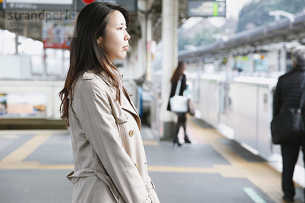 Junge attraktive Japanerin  die auf den Zug wartet
