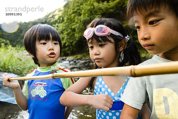 Japanische Kinder spielen am Fluss