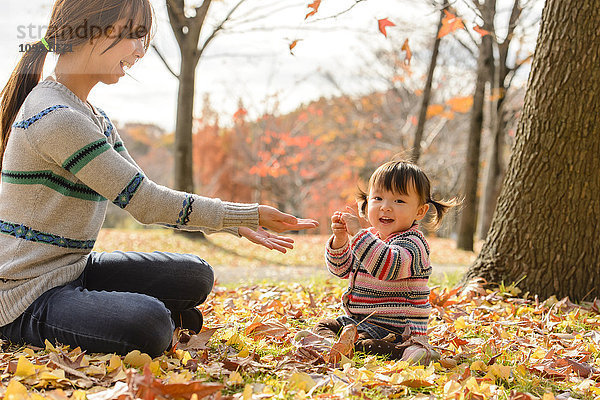 Kind spielt mit seiner Mutter im Park