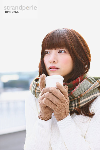 Attraktive Japanerin mit Kaffee an einem Wintertag