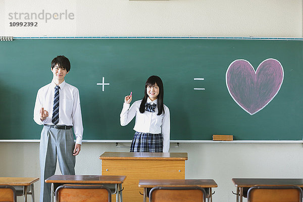 Japanische Gymnasiasten vor der Tafel im Klassenzimmer