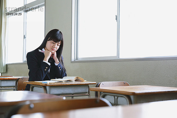 Japanische Schülerin in leerem Klassenzimmer