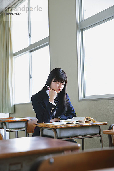 Japanische Schülerin in leerem Klassenzimmer