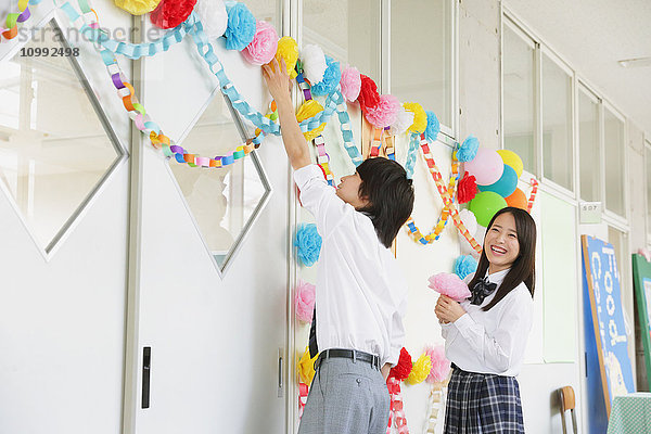 Japanische Gymnasiasten in einem dekorierten Schulflur
