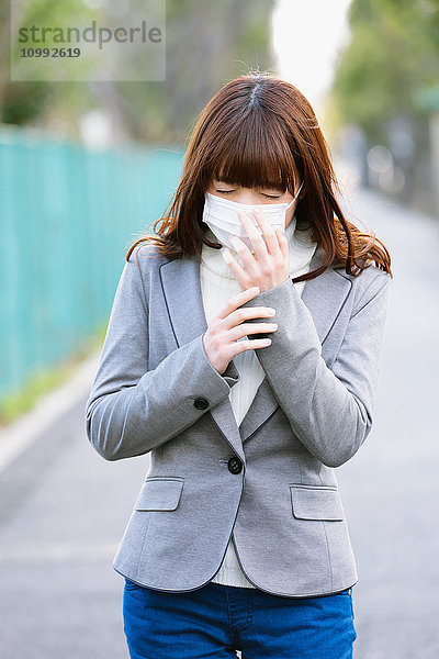 Attraktive japanische Frau  die sich an einem Wintertag krank fühlt