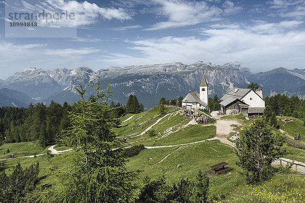 Blick auf die Berge mit der schönen kleinen Kirche des Heiligen Kreuzes  Gadertal  Dolomiten  Südtirol  Italien