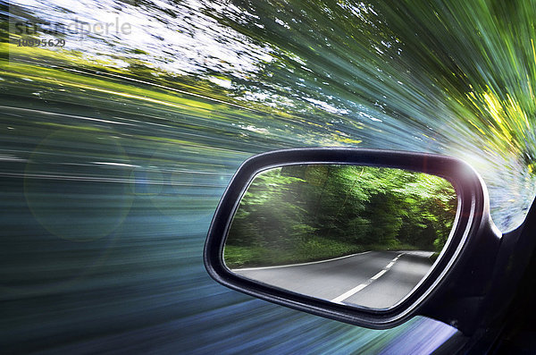 Blick auf die Straße  reflektiert im Außenspiegel des Autos