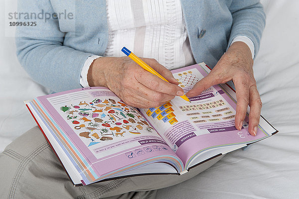 Ältere Frau bei Gedächtnis- und Logikspielen.