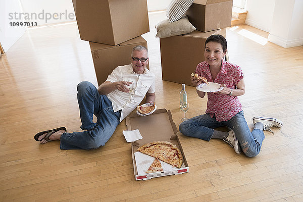 Pärchen isst Pizza in neuer Wohnung