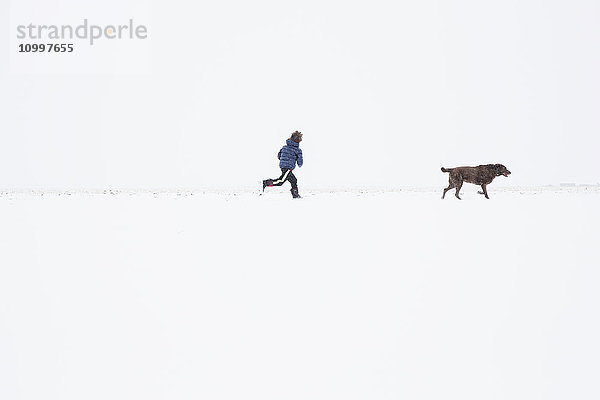 Junge (6-7) läuft mit Hund