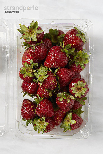 Draufsicht auf frische Erdbeeren in einem Plastikbehälter