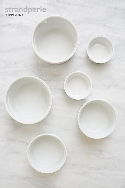 Draufsicht auf leere weiße Keramikschalen auf einem Marmortisch