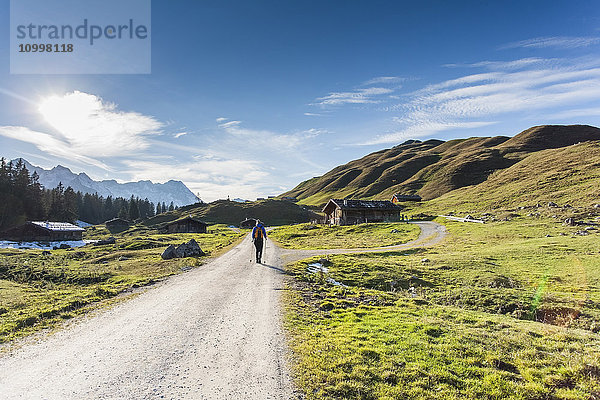Österreich  Salzburger Land  Weissbach  Ältere Frau wandert an einem sonnigen Tag in einer Berglandschaft