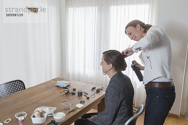 Frau stylt das Haar einer anderen Frau