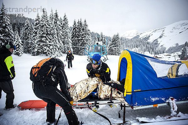 Reportage mit einem Ski-Patrouillen-Team im Skigebiet von Avoriaz in Haute Savoie  Frankreich. Das Team ist für die Markierung der Skipisten  die Erstversorgung von Skifahrern  Evakuierungen auf den Pisten sowie abseits der Pisten und kontrollierte Lawinenabgänge zuständig. Das Patrouillenteam evakuiert mit dem Hubschrauber eine Frau mit einer Schulterverletzung.