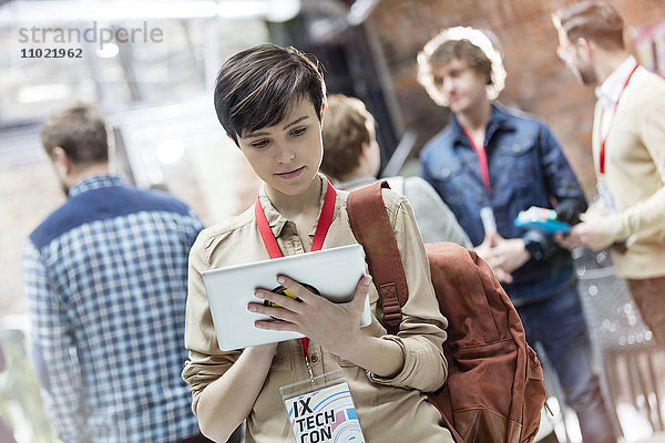 Junge Frau mit digitalem Tablett auf Technologie-Konferenz