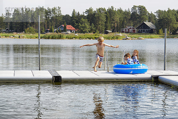 Junge springt vom Dock in den See