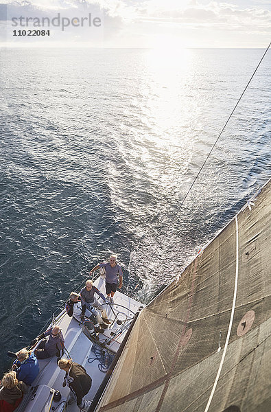 Freunde segeln auf einem Segelboot auf dem sonnigen Ozean