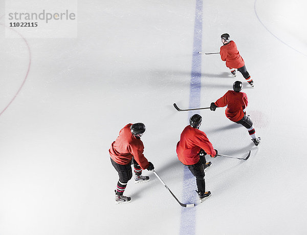 Eishockeymannschaft in roten Uniformen Schlittschuhlaufen auf dem Eis