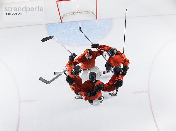 Overheadansicht Eishockeymannschaft in roten Uniformen auf dem Eis