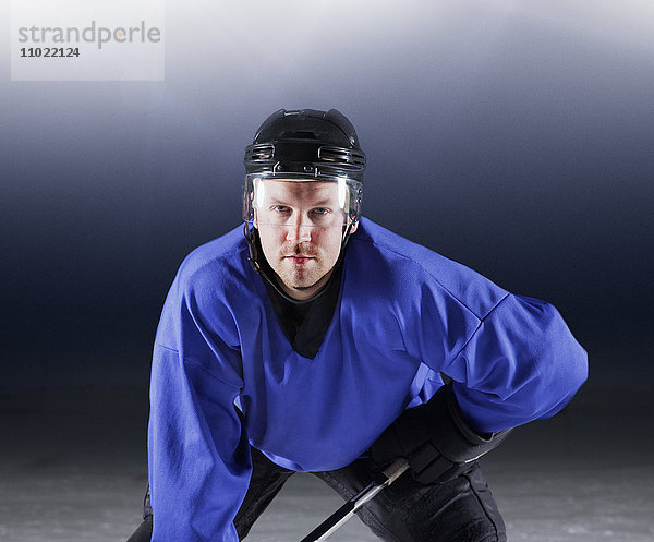 Portraitierter Hockeyspieler in blauer Uniform auf Eis