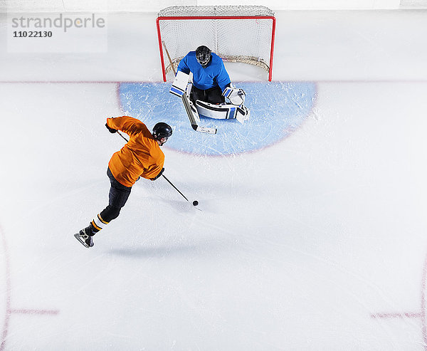 Hockeyspieler schießt den Puck auf das Tornetz