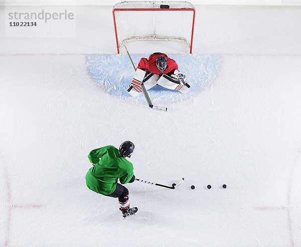 Overhead-Ansicht Hockeyspieler beim Üben mit dem Torwartschützenpuck am Tornetz