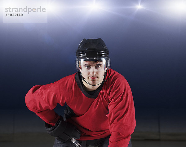 Portrait selbstbewusster Hockeyspieler in roter Uniform