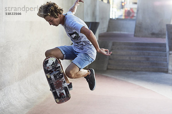 Teenager Junge flippt Skateboard im Skatepark