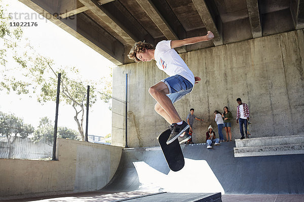 Teenager Junge flippt Skateboard im Skatepark