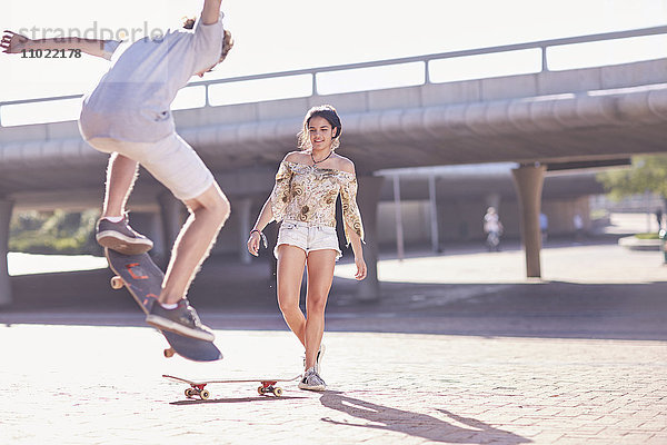 Teenager Skateboardfahren für Jungen und Mädchen im sonnigen Skatepark