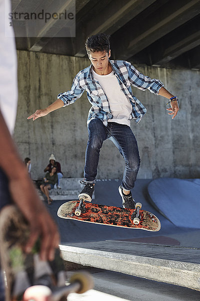 Fokussierter Teenager beim Skateboardfahren im Skatepark